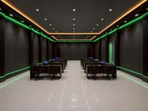a conference room with tables and chairs and green lights at Loei Buri Hotel by Alphatel in Ban Tha Phae