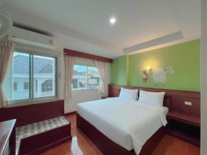 a bedroom with a white bed and a green wall at Loei Buri Hotel by Alphatel in Ban Tha Phae +21 photos