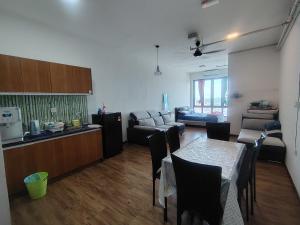 a kitchen and a living room with a table and a couch at Suria jaya studio condo shah alam in Shah Alam