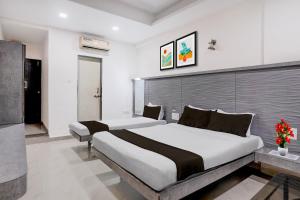 a bedroom with two beds in a room at Hotel O Kolhapur Gate Formerly Tanwani Lodging in Unchagao +25 photos