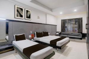 a bedroom with two beds in a room at Hotel O Kolhapur Gate Formerly Tanwani Lodging in Unchagao