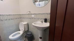 a small bathroom with a toilet and a sink at Spacious Suite privacy, and comfort in Riobamba