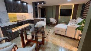 a kitchen and a living room with a glass table at Spacious Suite privacy, and comfort in Riobamba