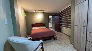 a bedroom with a bed and a chair in it at Spacious Suite privacy, and comfort in Riobamba