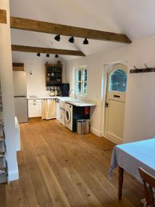 a kitchen with white cabinets and a wooden floor at Park Cottage cabin in Bix