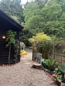 a garden with a bench next to a fence at Park Cottage cabin in Bix