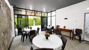 a restaurant with two tables and a piano at Cemara Asri Guesthouse in Lembang