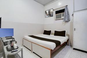 a white bedroom with a bed and a window at Super Hotel O Gaya Railway Station Formerly Vishal Inn in Gaya