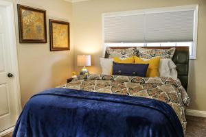 a bedroom with a large bed with a blue comforter at Wonderful 4 Bedroom 3 Bath Pool Home 3/4 Mile To Disney in Anaheim