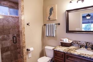 a bathroom with a toilet and a sink and a mirror at Wonderful 4 Bedroom 3 Bath Pool Home 3/4 Mile To Disney in Anaheim +13 photos