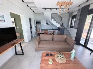 a living room with a couch and a table at Ciel Seafront Suites - Maisonette in Lygia +36 photos