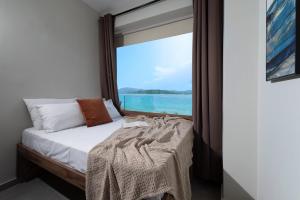 a bedroom with a bed and a window with the ocean at Ciel Seafront Suites - Maisonette in Lygia
