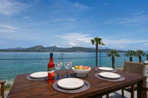 a wooden table with a bottle of wine and a bowl of fruit at Ciel Seafront Suites - Maisonette in Lygia