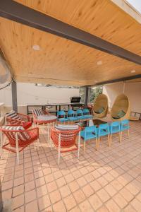 a patio with chairs and tables and a piano at The Mars Sphere in Dehradun