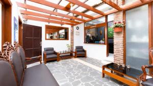 a conservatory with a patio with chairs and a door at Cemara Asri Guesthouse in Lembang