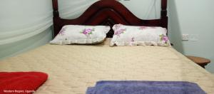 a bed with two pillows on top of it at WYCLIFF BnB in Chabahinga +18 photos