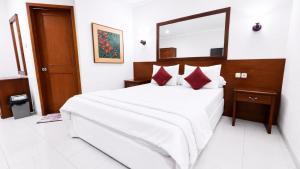a bedroom with a large bed with a large mirror at Cemara Asri Guesthouse in Lembang