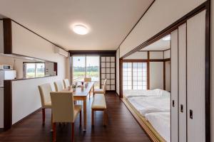 a dining room with a table and a bed at NASU den-en in Nasu