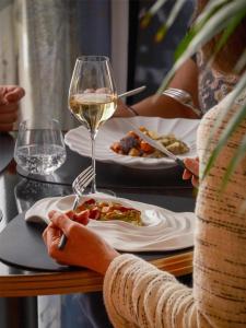 a woman is holding a glass of white wine at Hyatt Centric Reims in Reims +117 photos