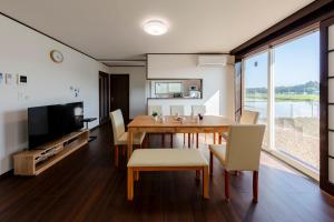 a dining room with a table and chairs and a television at NASU den-en in Nasu
