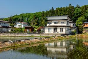 a house next to a river with houses at NASU den-en in Nasu
