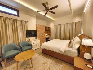 a bedroom with a bed and a tv and a chair at The Mars Sphere in Dehradun
