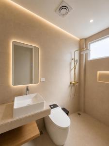 a bathroom with a white toilet and a sink at Hotel K Seminyak in Badung +16 photos