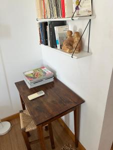 a wooden table with a book shelf with books at Bastide le Petit Clos - les 2 Gîtes in Perpignan