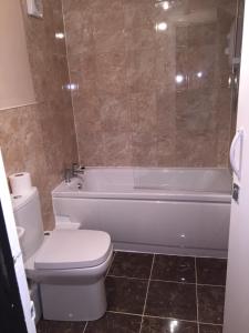 a bathroom with a toilet and a tub and a sink at Villa Bianca B&B in Penrith +20 photos