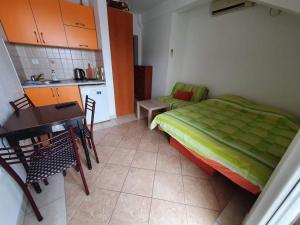 a bedroom with a bed and a table and a kitchen at Vukovic View Apartment in Topla