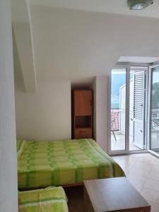 a bedroom with a bed and a balcony at Vukovic View Apartment in Topla