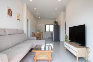 a living room with a couch and a table at Pool Villa Maephim 4, by Somjai in Klaeng