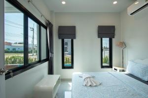 a bedroom with white walls and windows and a bed at Pool Villa Maephim 4, by Somjai in Klaeng +30 photos
