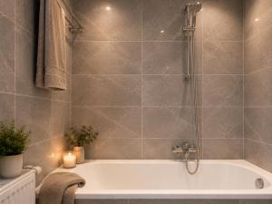a bathroom with a bath tub with a shower at Ferienwohnung Melissa in Unter Feuchten +19 photos