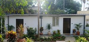 a white house with plants in front of it at Tranquil Tents in Trivandrum