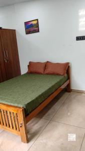 a bed in a room with a green mattress at Tranquil Tents in Trivandrum