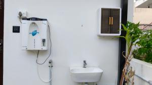 a bathroom with a sink and a phone on the wall at Tranquil Tents in Trivandrum