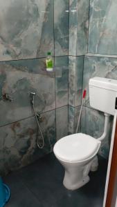 a bathroom with a white toilet in a room at Tranquil Tents in Trivandrum