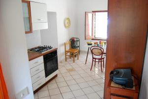 cocina con fogones y mesa con sillas en Dammusi Punta Fram, en Pantelleria