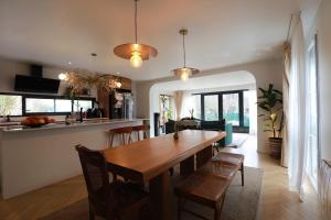 a kitchen and dining room with a wooden table and chairs at The Gentle Stay in Brunoy