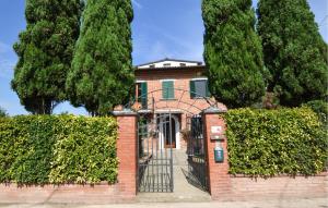 a brick house with a gate and trees at Pet Friendly Home In Sinalunga in Sinalunga +15 photos