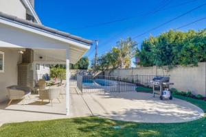 a patio with chairs and a grill in a yard at Gorgeous Upgraded 5 Bedroom & 3 Bath Home with pool in Orange