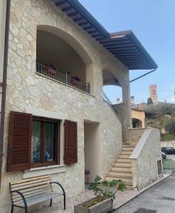 a building with a bench in front of a balcony at Hotel Collina di San Sisto in San Sisto