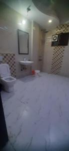 a bathroom with a toilet and a sink at ADA Residency in Noida