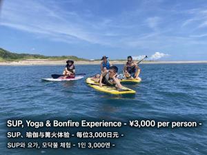 a group of people riding on kayaks in the water at SUNAORetreat奥白浜 in Minamiboso