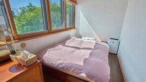 a small bed in a room with windows at Shinwaso Kaishin in Amakusa