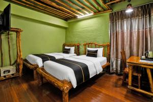 two beds in a room with green walls at Townhouse Near Tanjung Batu Formerly 900 Inn in Bintulu