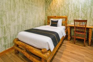 a bedroom with a bed and a table and a chair at Townhouse Near Tanjung Batu Formerly 900 Inn in Bintulu