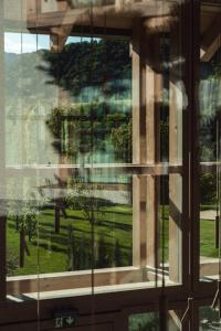 a window with a view of a park through it at Zen Emerald Resort & Spa, Soča river in Most na Soči