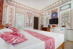 a bedroom with a large bed with colorful wallpaper at Ismat Premium Guest House in Bukhara